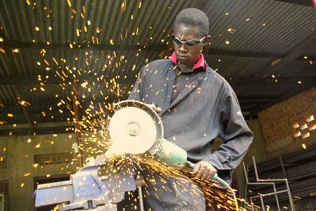 A factory worker using an angle grinder