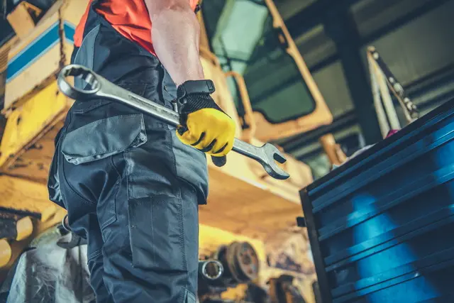 A maintenance worker with a large wrench